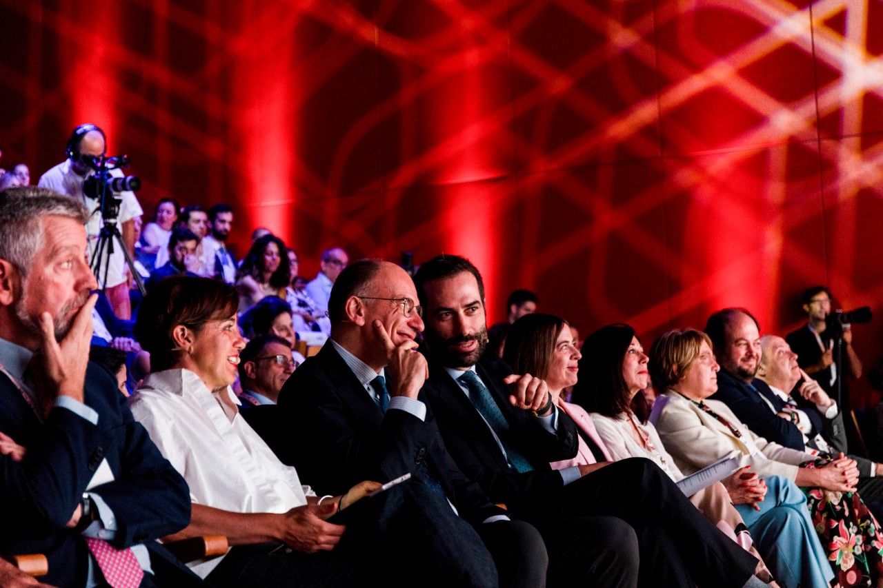personas sentadas hablando en un auditorio